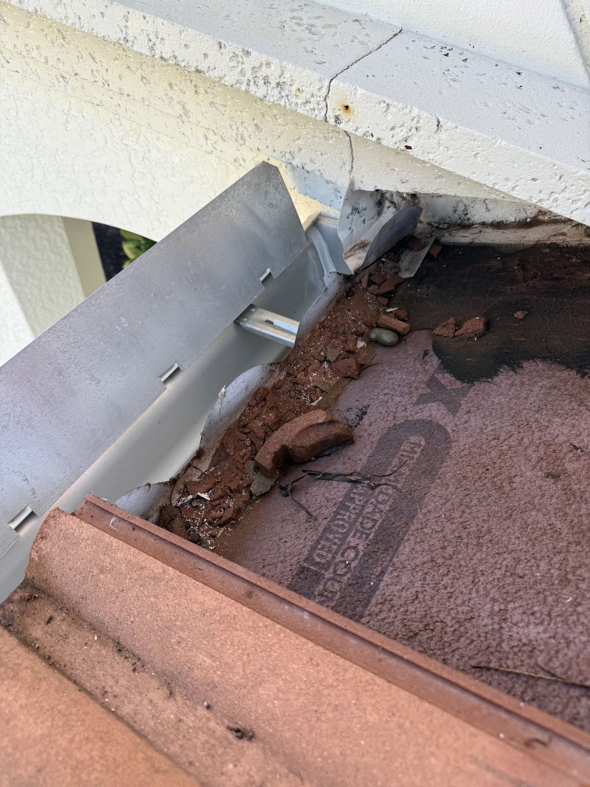 Debris blocking eave enclosure drainage holes